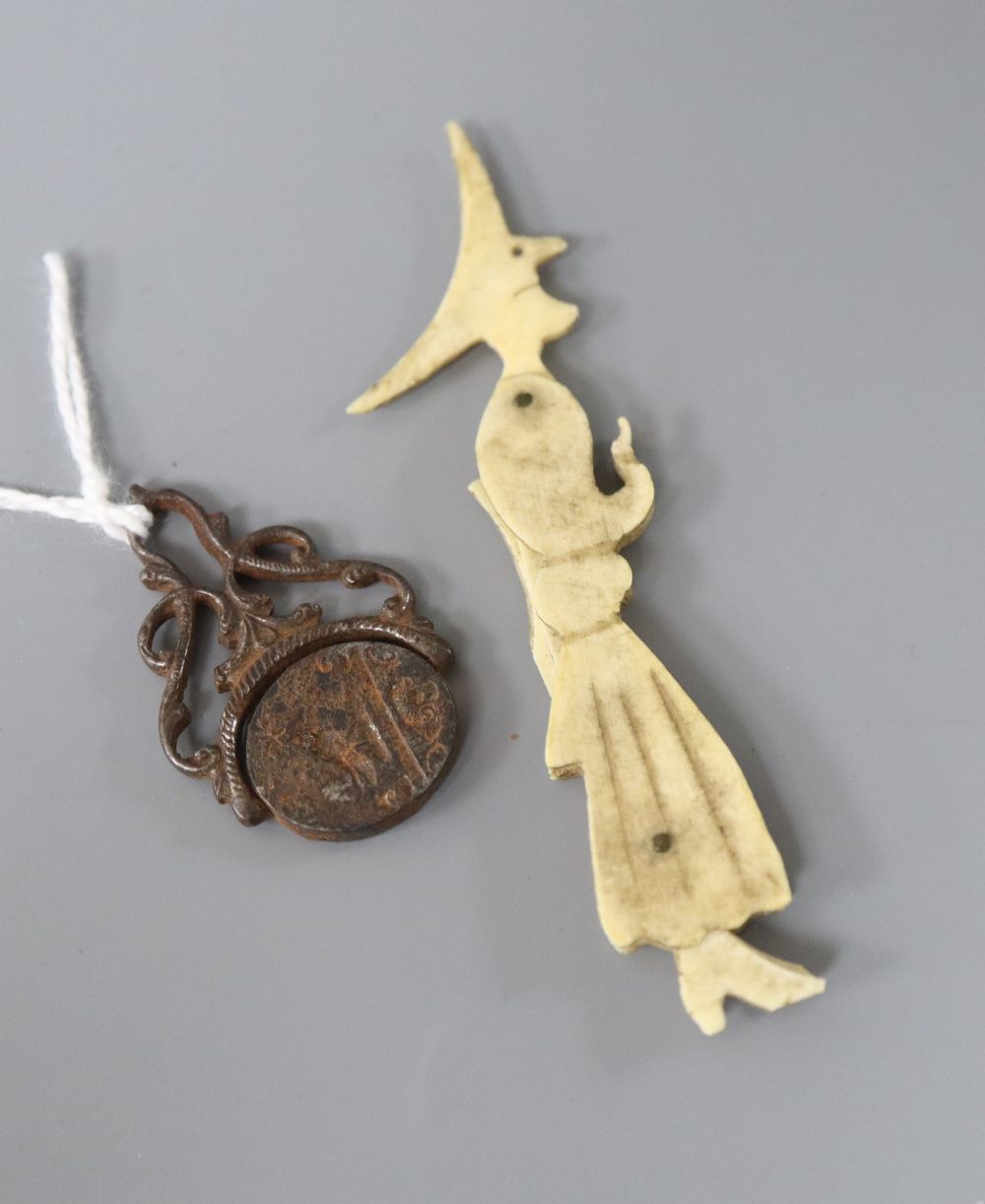 A novelty bone witch and broomstick and an early cut steel swivel fob